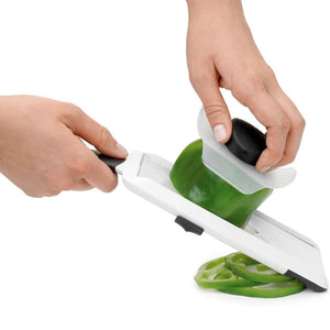 Person slicing a bell pepper using a OXO Good Grips Hand Held Mandoline Slicer with the safety guard.