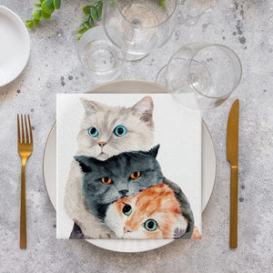 PAW Better Together Paper Napkins styled on a stone table with gold cutlery and wine glasses.