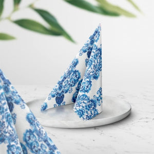 PAW Porcelain Ornament Paper Napkins marble surface with green leaves in the background.
