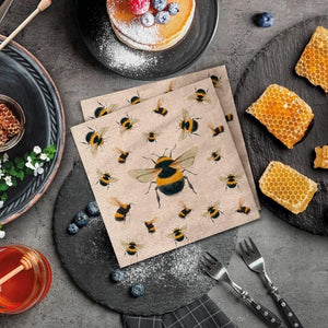 PAW We Care Dancing Bees Paper Napkins styled on a stone table with honeycomb and berries.