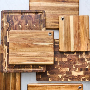 Peer Sorensen End Grain Cutting Board and long grain cutting boards styled on a marble surface.
