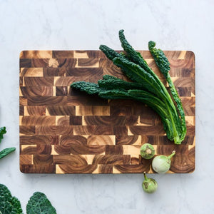 Peer Sorensen End Grain Cutting Board with kale on a marble surface.