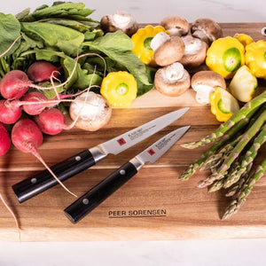 Acacia chopping board with fresh vegetables and two kitchen knives