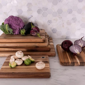 Stacked Peer Sorensen long grain acacia chopping boards with mushrooms, onions, and broccoli displayed on top.