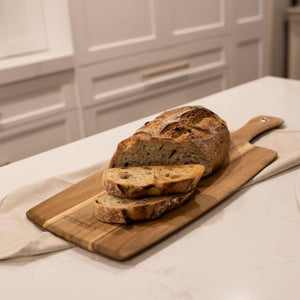 Peer Sorensen Paddle Serving Board - long acacia serving board on a kitchen bench topped with sliced bread.