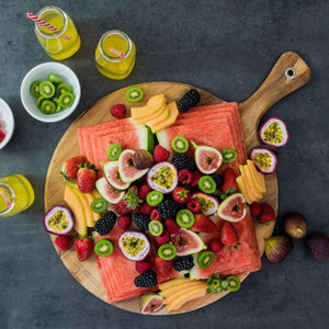 Round paddle board by Peer Sorensen loaded with fresh fruit displayed on a table