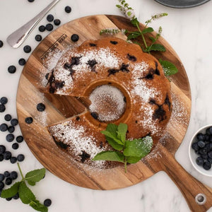 Peer Sorensen Round Paddle Serving Board styled with a dusted cake and fresh berries