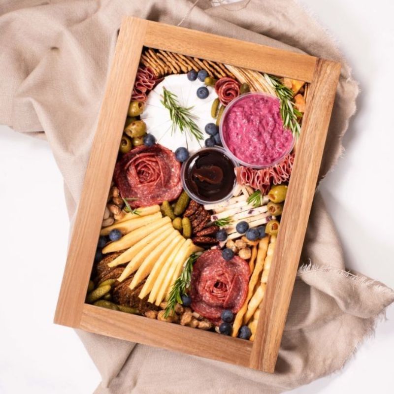 Top view of Peer Sorensen Grazing Box filled with cheese, meats, dips, pickles and fruits - shown with lid on.