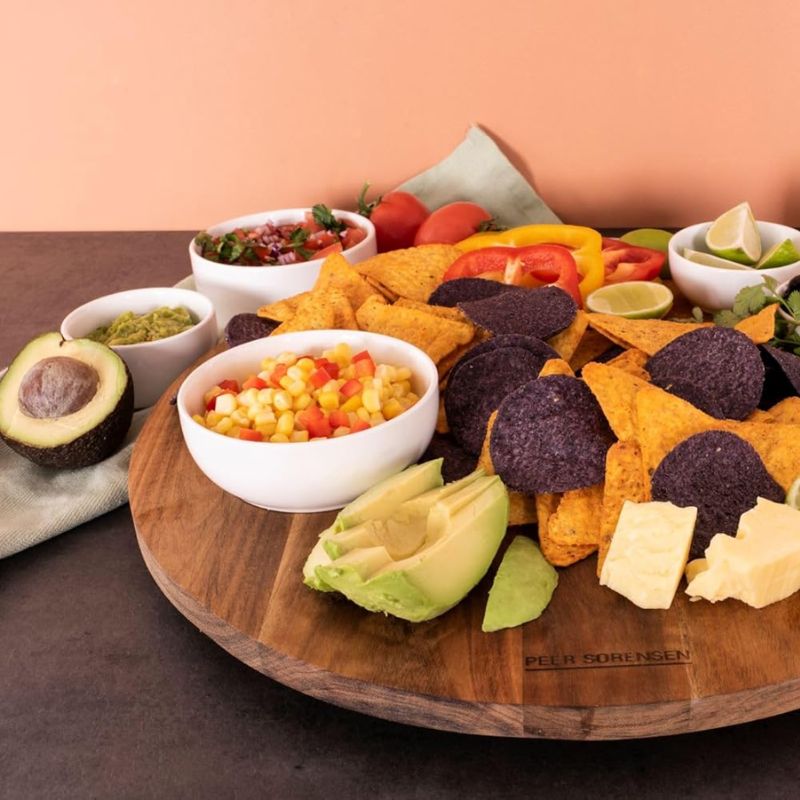 Peer Sorensen Lazy Susan with corn chips, avocado, cheese and vegetables served directly on top alongside bowls of guacamole and salsa.
