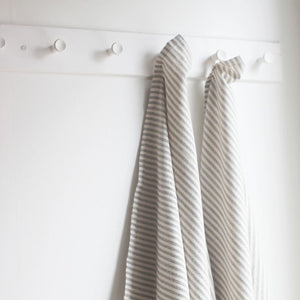Charcoal striped tea towel on natural woven cotton