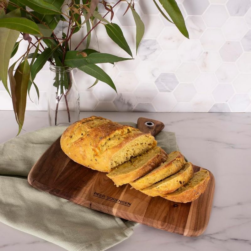 Acacia wood serving board with handle and visible grain variations.