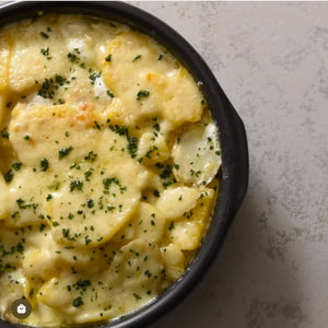 Scalloped potatoes in a Regas Spanish Terracotta Black Professional Cazuela Baking Dish.