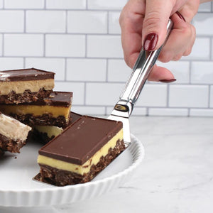 RSVP Stainless Steel Brownie Spatula holding a piece of caramel slice.