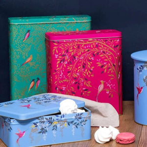 Sara Miller Chelsea Larder Tin next to coordinating light blue biscuit tins and a teal tin.
