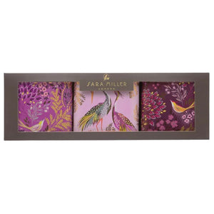 Sara Miller Haveli Garden Square Tin Caddies (Set of 3) featuring purple, pink, and deep magenta floral and animal patterns with gold details, in a dark brown packaging.