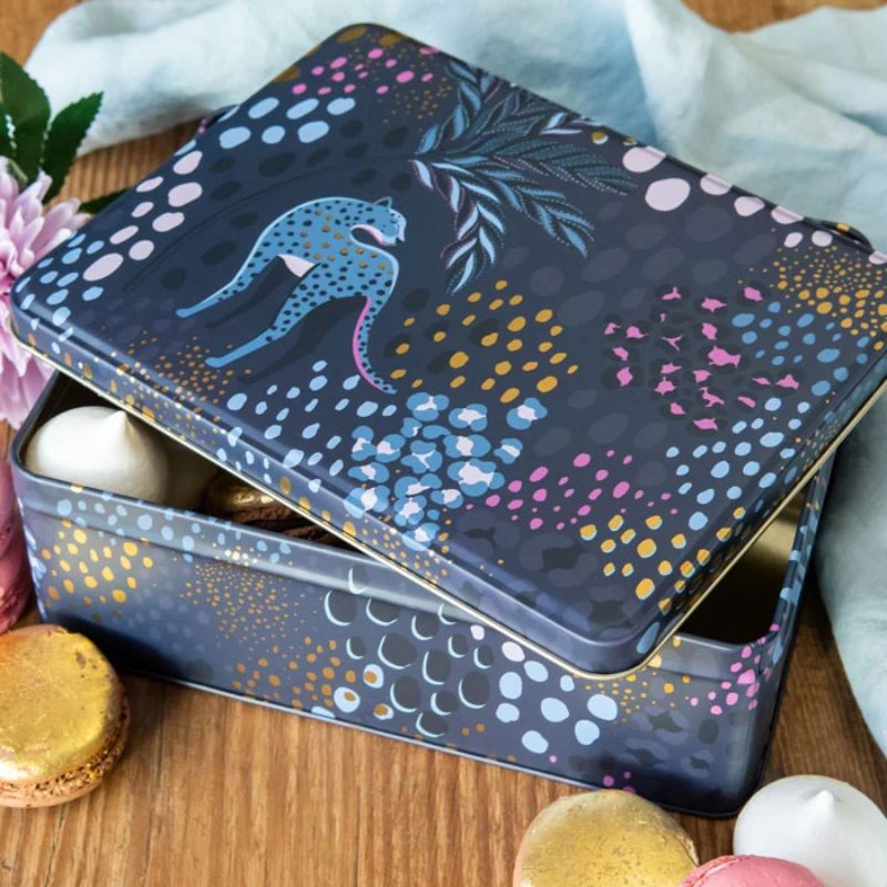 Sara Miller Midnight Leopard Biscuit Tin with a dark navy blue background and a vibrant, multicoloured abstract pattern featuring blue, yellow, pink, and purple dots and leaf-like shapes, shown on a plain white background.