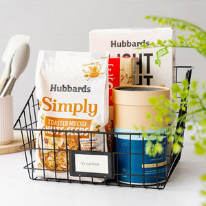 Seymours large black wire basket holding cereal boxes and collagen powder for pantry storage