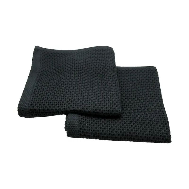 Two black Simple Things cotton wash cloths laid flat on a white background.