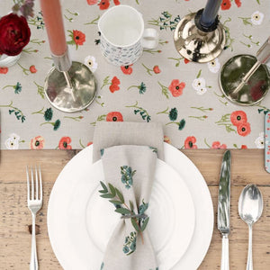 Close up of the Poppy Meadow table runner set on a rustic table with candles, plates, cutlery and foliage - Sophie Allport NZ