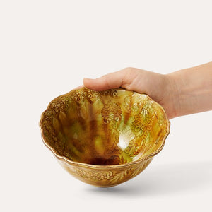 Hand holding the Sthal Arabesque Breakfast / Soup Bowl in Pineapple against a white background.