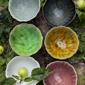 Collection of Sthal Arabesque breakfast / soup bowls in a variety of colours with natural elements like leaves and apples on a rustic background.