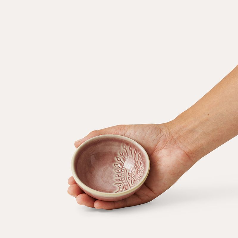 Hand holding Sthal Arabesque Old Rose small dip bowl highlighting interior design.