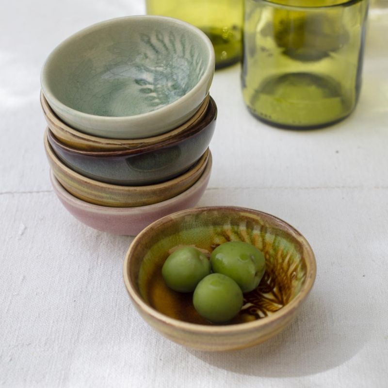 Stack of assorted Sthal Arabesque small dip bowls, Antique bowl on top, next to fresh green olives.