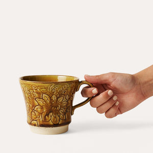 Hand holding the Sthal Arabesque Pineapple Tea Mug against a white background.