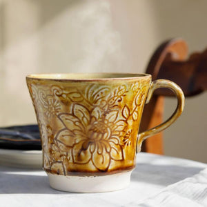 The Sthal Arabesque Pineapple Tea Mug, a ceramic mug with floral design at a table setting.