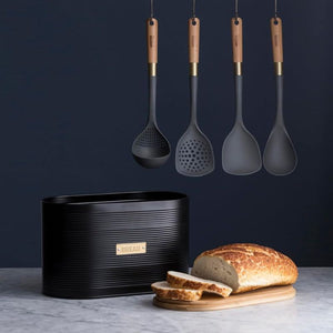 Typhoon Otto Bread Bin in Black styled on a kitchen bench with matching typhoon utensils hanging above