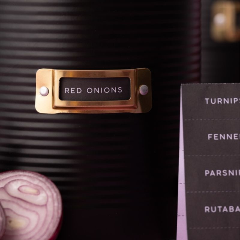 Smaller black canister showing a close up of the red onions name tag - part of the Typhoon Otto Root Vegetable Storage Canisters Set NZ
