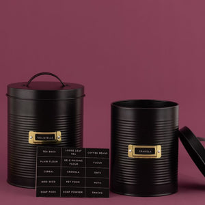 Two black Typhoon Otto storage canisters shown with label options on a pink background