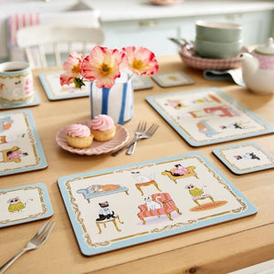 Ulster Weavers Cool Cats Coasters paired next to the matching placemats on a wooden table.