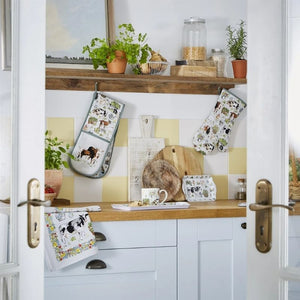 Kitchen interior with wooden countertop, white cabinets, and items from the Ulster Weavers Portman Farm collection.