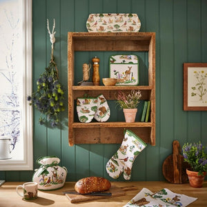 Ulster Weavers Thistlewood collection styled on a wooden shelf with decorative items against a green wall, including a loaf of bread on a wooden table.