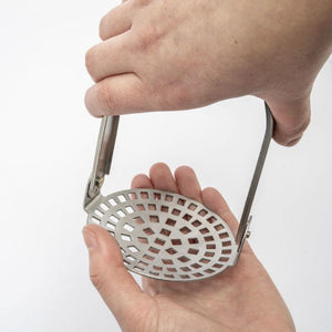 Westmark Folding Potato Masher close-up showing the folding mechanism being opened by hand
