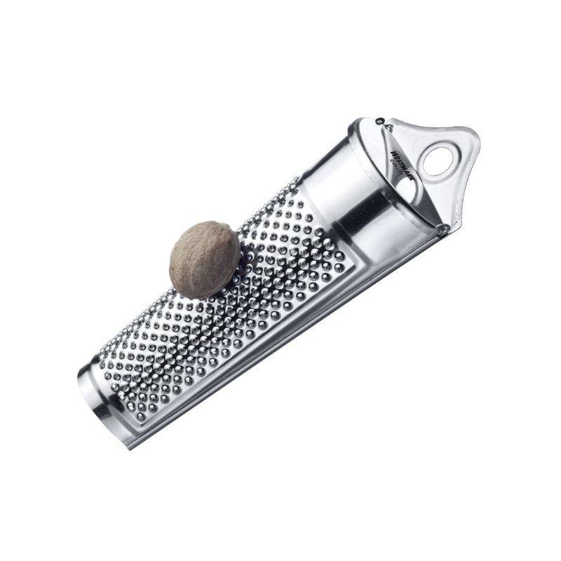 Westmark Nutmeg Grater with whole nutmeg on stainless steel grating surface - hanging hole shown