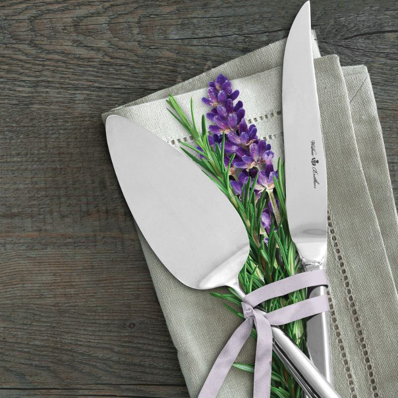 Close up of the Wilkie Brothers Stirling Cake Serving Set shown on a linen napkin with fresh lavender