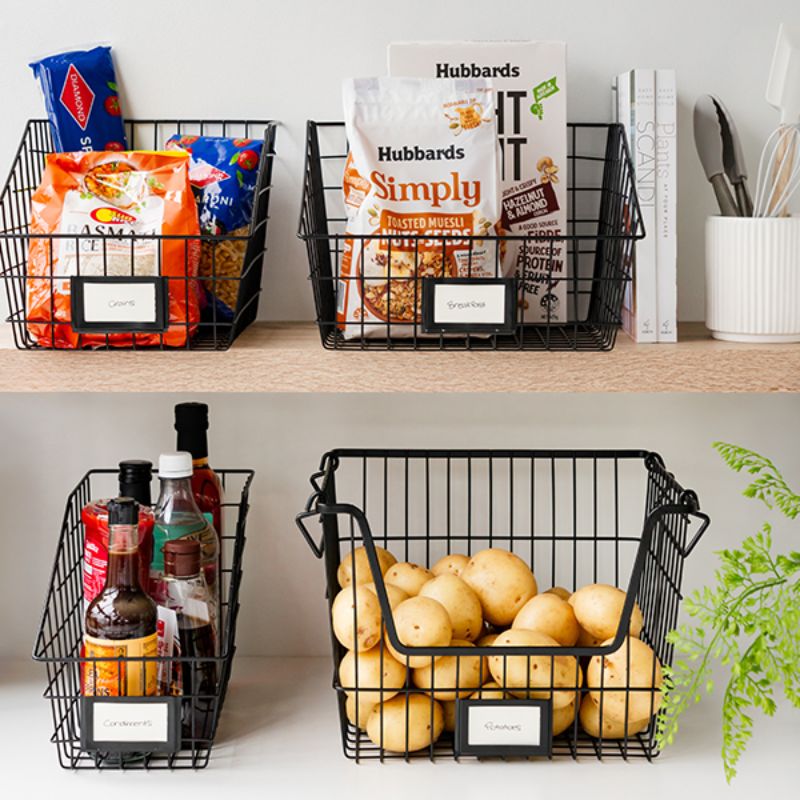 Black wire storage baskets on pantry shelf with groceries and potatoes