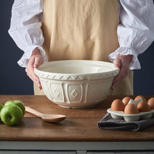 Person holding the Mason Cash Cream Mixing Bowl on a table with eggs, apples